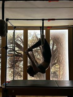 a man is doing a handstand on a bench in front of a window