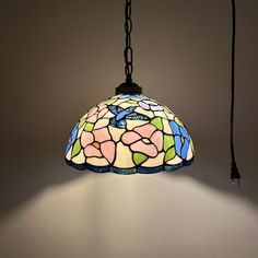 a stained glass light hanging from a ceiling fixture with a chain attached to the end