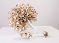 a bridal bouquet with hair combs and flowers on the table next to it