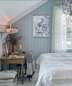 a bedroom with blue walls and white bedding