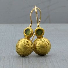 "22k gold dome and green Peridot earrings which not only bring your attire together but are also a stunning statement, look no further than these marvelous 22k solid gold earrings. The backs are secured with 9k gold while the locking French wires are handmade with 14k yellow gold. Earrings Width - 0.43''( 11 mm). Length without the ear wire - 0.7\" (17 mm). Length from top of the ear wire to bottom of the earring - 1.1\" (29 mm). The earrings will be packed in a gift box ready to give as a gift. Formal Green 22k Gold Earrings, 22k Gold Gemstone Round Earrings, Elegant Green Hammered Earrings, Silver Bar Bracelet, Dome Earrings, Organic Earrings, Vintage Drop Earrings, Gold Bar Earrings, Face Necklace