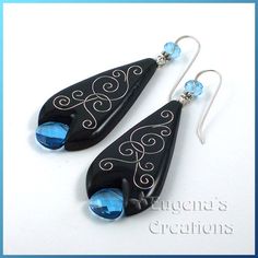 pair of black and blue earrings with swirl design on white background, featuring crystal beads