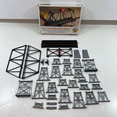 an assortment of model railroad tracks and trusses on a table with the box open