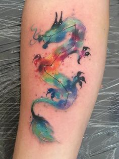 a watercolor tattoo with an arrow and stars on it