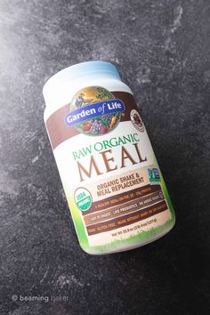 a jar of raw organic meal on a black countertop with the lid off and an empty container next to it