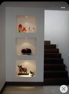 a room with some shelves on the wall and a cake in front of it that is lit up