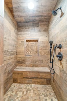 a bathroom with wooden walls and tile flooring, including a bench in the shower