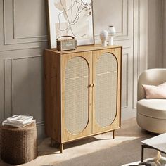 a living room with a white chair and a wooden cabinet in the middle of it