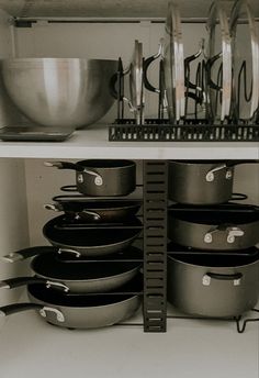 pots and pans are stacked on the shelf