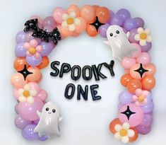 a balloon wreath that says spooky one with ghost balloons and flowers around it