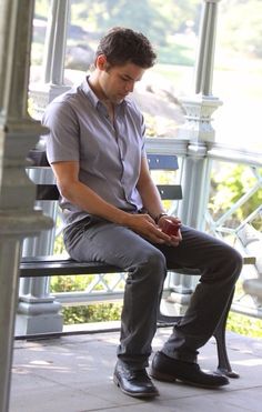 a man sitting on a bench holding an apple