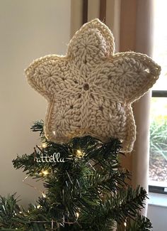 a crocheted star ornament on top of a christmas tree with lights