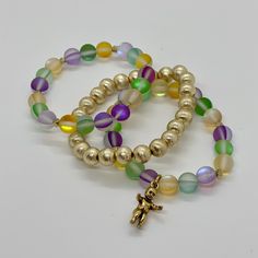 Bring on the Mardi Gras season with this super fun stack! This Hand Beaded set of 3 stack bracelets includes:- 8mm brushed gold round bracelet- Mardi Gras mix Aura Quartz with gold accents- Mardi Gras mix Aura Quarts with gold accents and King Cake baby charm. Bracelets are “one size fits most” and are designed to fit wrists up to 7.0”. Custom sizes available upon request. Please email designsby.kb@yahoo.com once your oder is placed. *Bracelets usually ship within 3-5 business days. King Cake Baby, Stack Bracelets, Round Bracelet, King Cake, Aura Quartz, Bracelet Stack, Hand Beading, Charm Bracelets, Gold Accents