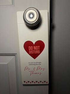 a door hanger with a red heart and do not disturb sign on the front