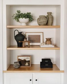 some shelves with vases and pictures on them