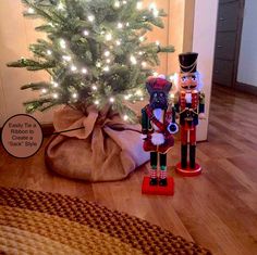 two nutcrackers are standing next to a christmas tree