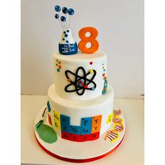 a three tiered cake with science themed decorations