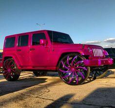 a pink jeep parked on top of a parking lot