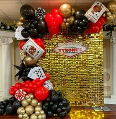 a table topped with balloons and casino themed items in front of a golden backdrop that reads, tonyton's