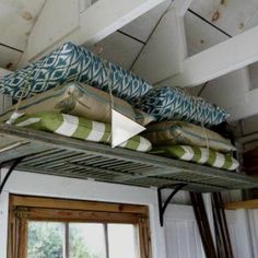 there are many pillows on top of the bed rails in this room, and one is upside down