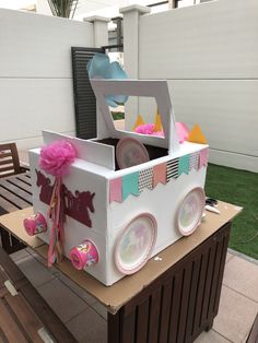 a cardboard box with plates in it sitting on top of a wooden table next to a bench