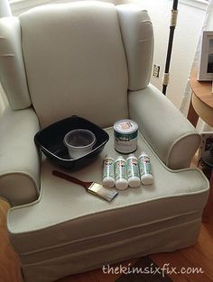 a chair with some paint on it next to two cans of toothpaste and a brush