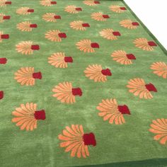 a green rug with orange and red flowers on it