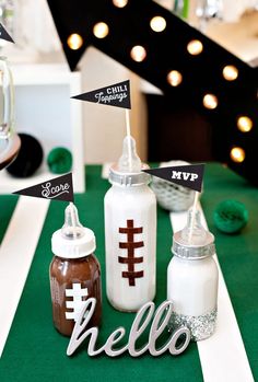 two baby bottles are sitting next to each other on a green tablecloth with black and white flags