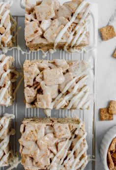 several pieces of bread with white icing on a cooling rack next to other desserts