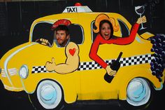 a man and woman are in a taxi painted on the side of a building