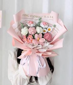 a woman holding a bouquet of pink and white flowers in front of a sign that says ding flower is a tea