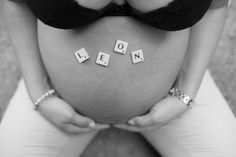 a pregnant woman holding her stomach with the word leon spelled in small letters on it