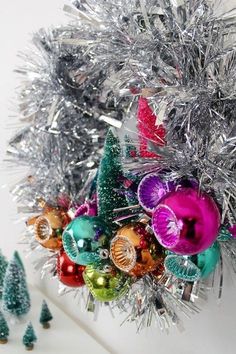 a bunch of ornaments are hanging on the wall in front of some christmas tree decorations