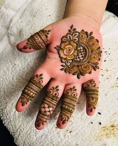 a woman's hand with henna tattoos on it