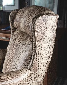 an upholstered chair sitting in front of a wooden table