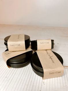 three black plates with labels on them sitting on a table next to some paper tags