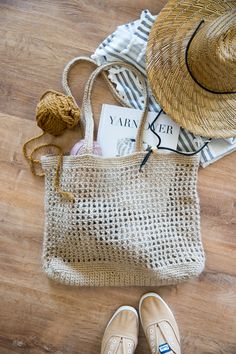 a pair of shoes and a straw hat are on the floor next to a bag