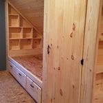 an unfinished bed in a room with wooden shelves