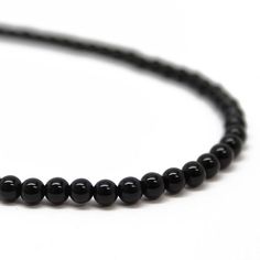 Black Onyx beads are hand strung to form this classic single strand necklace.  The beads are small measuring about 4.0mm.  This is a beautiful, classic black onyx bead necklace.  You could wear this alone or stack with other necklaces for a layering effect.  • 4mm round black Onyx beads• 925 Sterling silver or 14/20 Gold FIlled clasp and ring • Available in 14" to 35" lengthsI have hand strung these beads using a premium beading wire that has beautiful drape and it fastens with a sterling silver Onyx Necklace With 8mm Round Beads, Black Onyx 8mm Beads, Onyx Bead Necklaces With 8mm Round Beads, Onyx Bead Necklace With 8mm Round Beads, Black Onyx Round Beaded Necklaces, Classic Onyx Beaded Necklace With Black Beads, Minimalist Black Gemstone Beaded Necklaces, Black Onyx Gemstone Beads, Minimalist Black Beaded Necklace With Gemstones