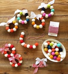 several different types of pom - poms are arranged on a wooden table next to a bowl of candy