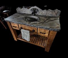 a bathroom vanity with marble counter top and wooden sink stand in front of black background