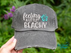 Save 15% off your first purchase by signing up at https://signup.sewvividdesigns.com 🌴 This cap features feeling a little beachy with a tropical flower embroidered on your choice of cap. Text will remain white unless otherwise noted. FEATURED CAP: Dk Grey Baseball with an Aqua flower. ✋ Does not include back of cap embroidery.  TO ADD BACK OF CAP EMBROIDERY: add this to your cart too-  https://etsy.me/2CZfOfQ 🧢 Cap Details 🧢 Baseball Style: Distressed 100% Cotton - Pigment Dyed Unstructured Low Profile Closure: Adjustable Metal Buckle Ponytail Style: Women's Fit Distressed 100% Cotton - Pigment Dyed Unstructured Low Profile **Top hole for Ponytail Closure: Adjustable Velcro strap Mesh Baseball Cap: DISTRESSED Mesh Baseball Cap:   55% Cotton / 45% Polyester  Unstructured Front  Low Profi Spring Beach Snapback Hat With Letter Print, Vacation Sun Hat With Letter Print And Curved Brim, One Size Letter Print Snapback Hat For The Beach, Fun Curved Bill Snapback Hat For Beach, Vacation Snapback Baseball Cap With Letter Print, Flat Brim Trucker Hat With Letter Print For Beach, Beach Snapback Hat With Letter Print, Beach Season Vacation Hat With Letter Print, Beach Snapback Cap With Letter Print