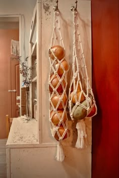 two macaroni and cheeses hanging from hooks on a wall in a kitchen