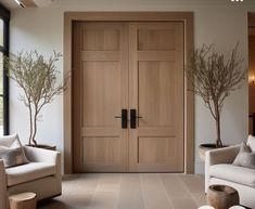 a living room with two white couches and wooden doors