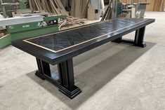 a long black table sitting on top of a floor next to other tables and chairs