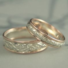 two gold wedding rings sitting next to each other