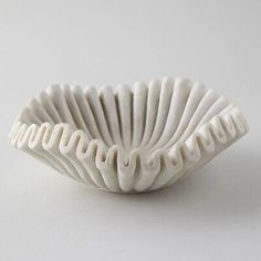 a white ceramic bowl with wavy designs on it