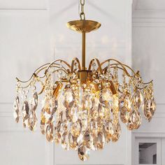 a chandelier hanging from the ceiling with lots of crystal drops on it's sides