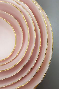 pink and gold plates stacked on top of each other