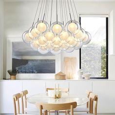 a modern chandelier hanging over a dining room table